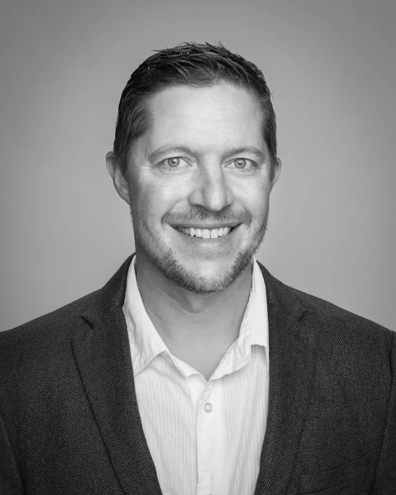 Black and white headshot of Zach Kuhlmann - Zero dB Communications